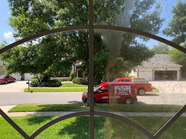 Fish Window Branded Van Through Window that is Half Clean and Half Dirty